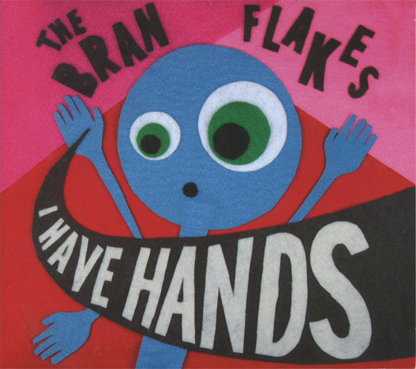  The album cover for I Have Hands. It consists of a curious looking, light blue stick figure with three arms behind a pink and red background. The figure is holding two of their hands up as the album name swooshes past them.